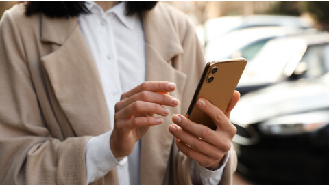 Close up of someone holding a smartphone up and browsing through it with both hands