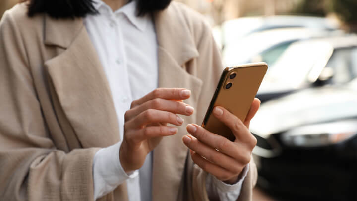Close up of someone holding a smartphone up and browsing through it with both hands