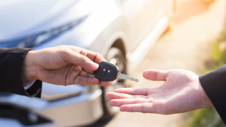 Close up of someone handing over some car keys to another hand