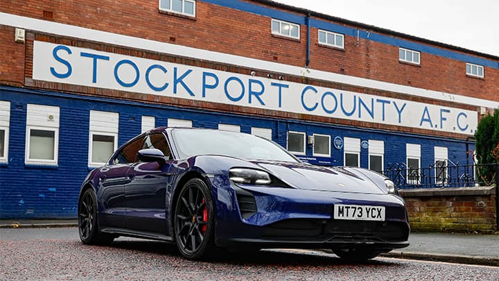 Blue Porsche Taycan parked outside Stockport County FC