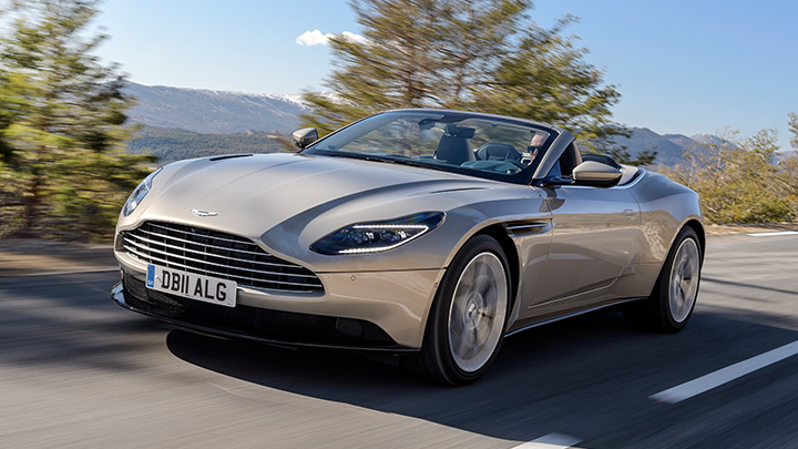 Pearl Blonde Aston Martin DB11 V8 Volante, driving with roof down