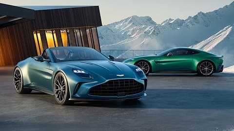Blue Aston Martin Vantage Roadster parked next to a green Aston Martin Vantage Coupe