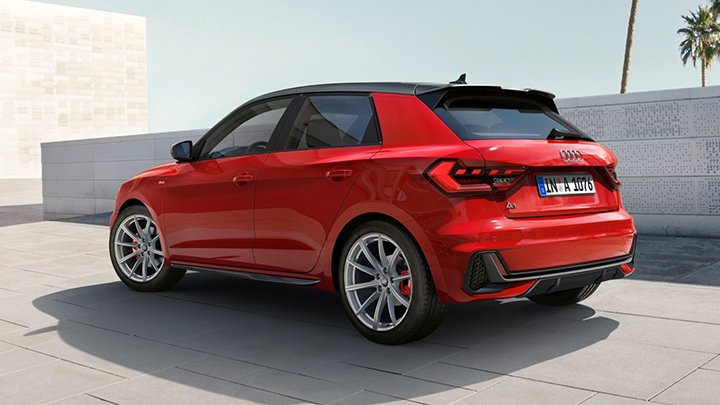Rear quarter shot of a red Audi A1 Sportback parked in front of a white wall