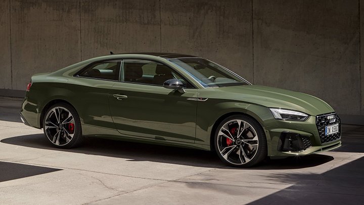 Side shot of a green Audi A5 Coupe, parked in front of a beige wall