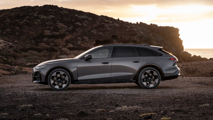 Side profile of a grey Audi A6 allroad quattro parked on a coastal landscape at sunset