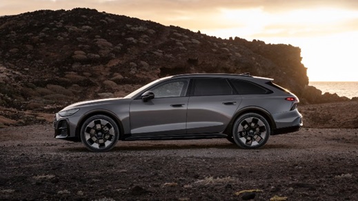Side profile of a grey Audi A6 allroad quattro parked on a coastal landscape at sunset