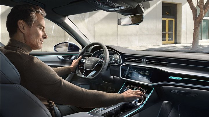 Middle aged man using the climate controls an Audi A6 Avant