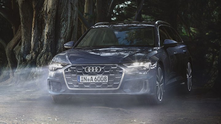 Moody shot of an Audi A6 Avant that's parked in mist with its lights on