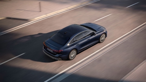 Dark Blue Audi A6 Saloon Driving rear zoomed out city street