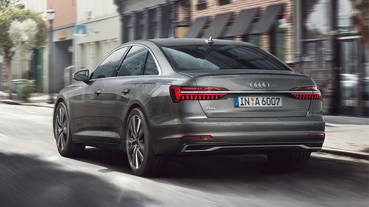 Rear quarter driving shot of a grey Audi A6 Saloon driving down a street