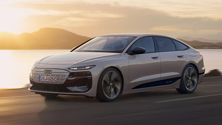 Front quarter driving shot of a silver Audi A6 Sportback e-tron, with a sunset background