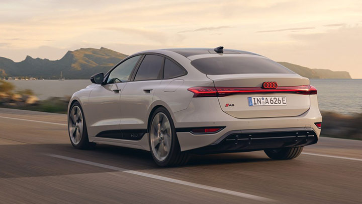 Rear driving shot of a silver Audi A6 Sportback e-tron, with a sunset background