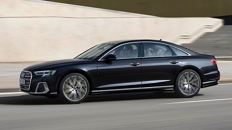 Side driving shot of a black Audi A8 driving down a street
