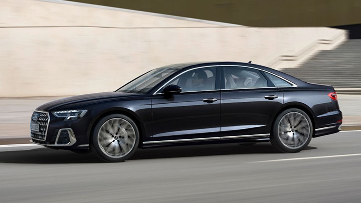 Side driving shot of a black Audi A8 driving down a street