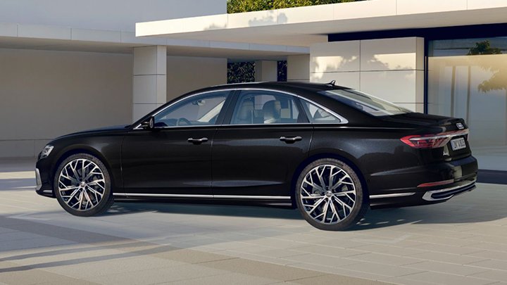 Side shot of a black Audi A8 that's parked outside a metropolitan building