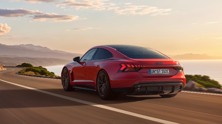 Red Audi e-tron GT Quattro driving rear coastal road
