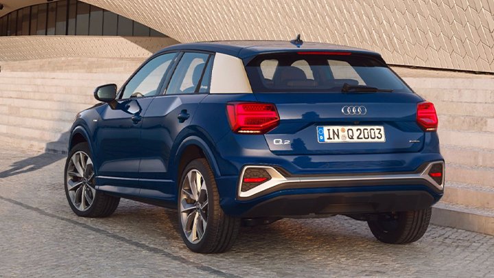 Rear quarter shot of a blue Audi Q2 with a low light created by sunset