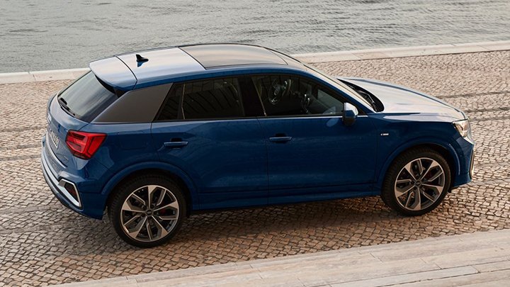 Side aerial shot of a blue Audi Q2 with a river in the background