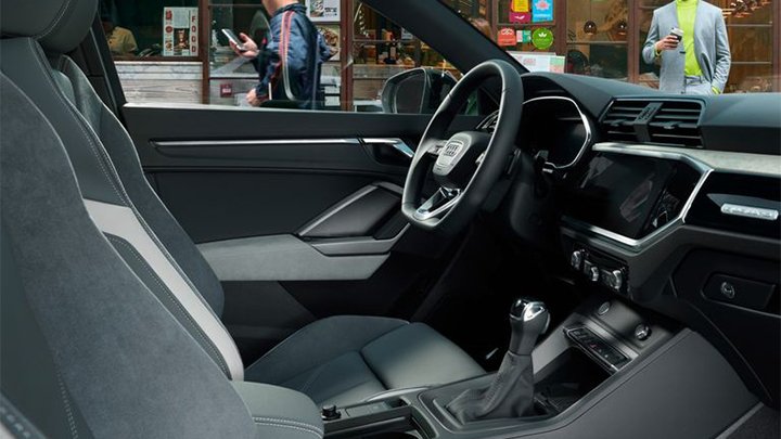 Side shot of an Audi Q3 Sportback's interior, including the seats and steering wheel