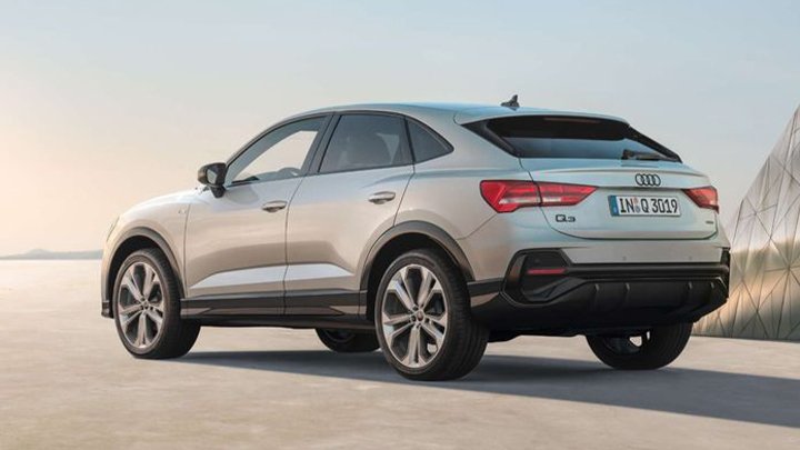 Rear quarter shot of a silver Audi Q3 Sportback with a sunset background
