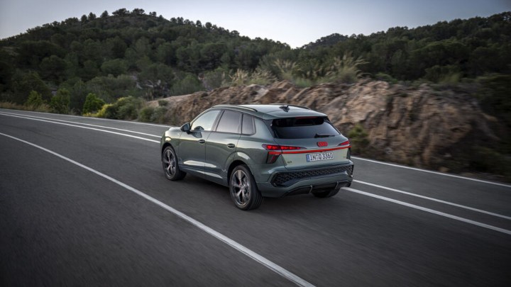 Green Audi Q3 Driving rear