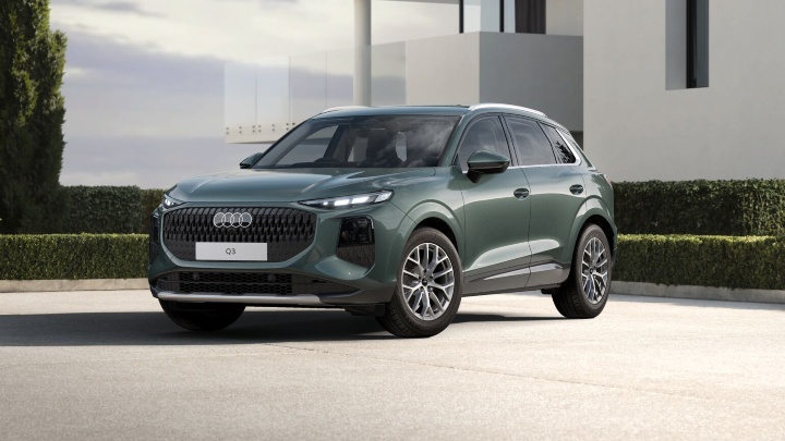 Green Audi Q3 SUV Sport trim modern building background 