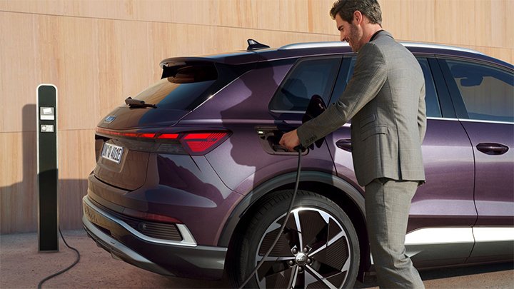 Close up of a man plugging in a purple Audi Q4 e-tron to charge