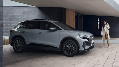 Woman Standing Next to Grey Audi Q4 e-tron