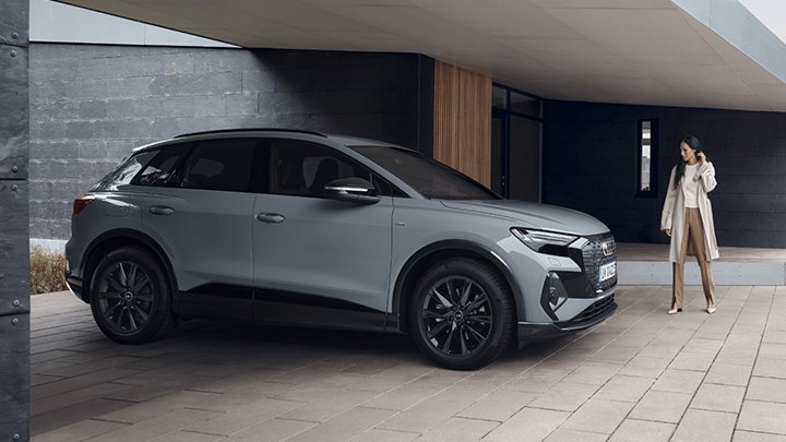 Woman Standing Next to Grey Audi Q4 e-tron