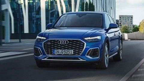 Front quarter shot of a blue Audi Q5 Sportback driving down a city street
