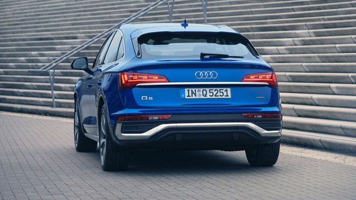 Rear shot of a blue Audi Q5 Sportback parked in front of some city stairs