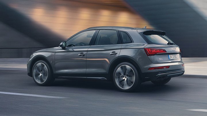 Rear quarter shot of a grey Audi Q5 driving down a city street
