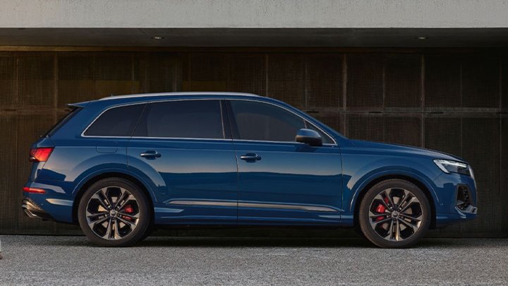 Side shot of a static blue Audi Q7 parked at sunset