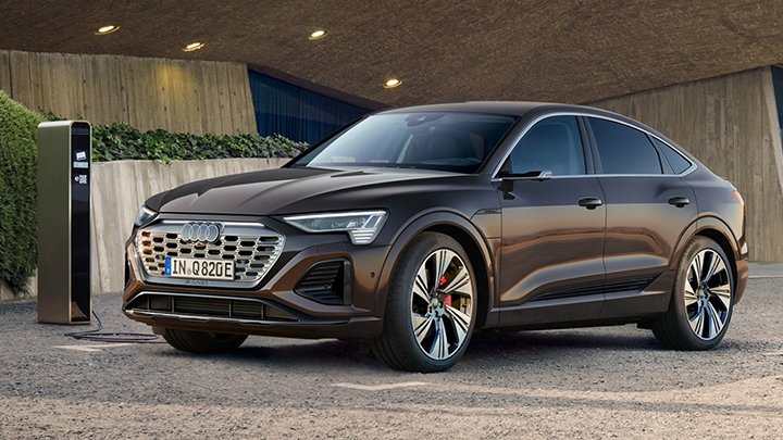 Front quarter shot of a black Audi Q8 Sportback e-tron on charge next to a modern building