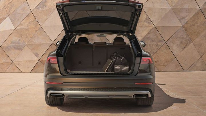 Rear shot of an Audi Q8 with an open boot and a duffle bag in storage