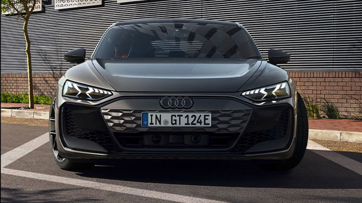 Front shot of a grey Audi RS e-tron GT with its headlights on