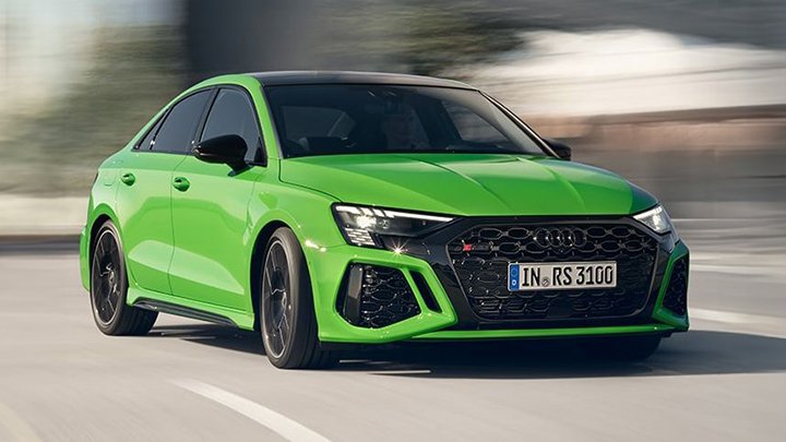 Green Audi RS 3 Saloon driving down a street
