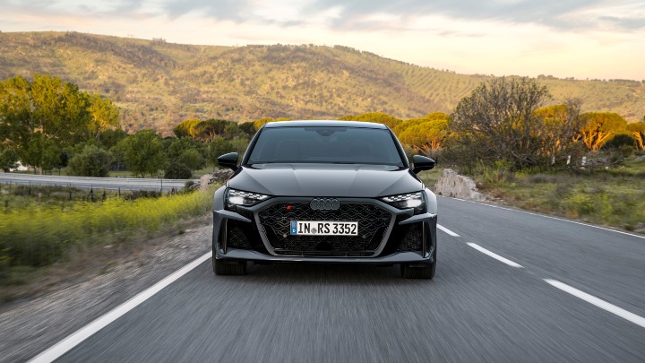 Front view of a grey Audi RS 3 Saloon driving along a countryside road