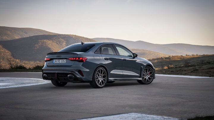 Rear three-quarter view of a grey Audi RS 3 Saloon in a scenic mountain setting