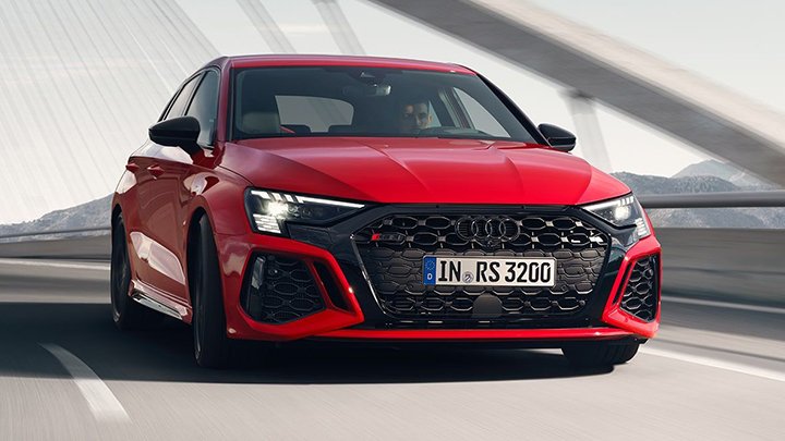 Front quarter shot of a red Audi RS 3 Sportback driving down a road