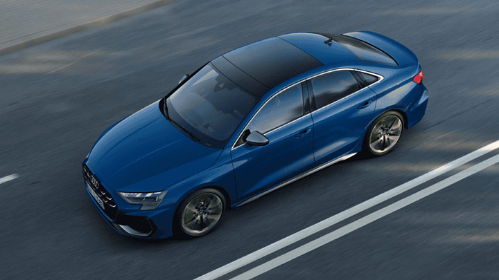 Aerial shot of a blue Audi S3 Saloon driving down a road