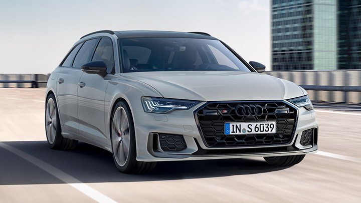 Light grey Audi S6 Avant driving on the bridge with a skyscraper in the background