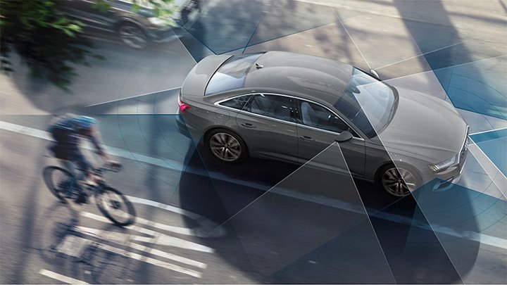 Grey Audi S6 Saloon parked in the city with a biker to its side