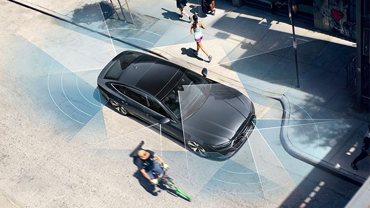 Black Audi S7 Sportback parked in the city with people running, biking and walking by it