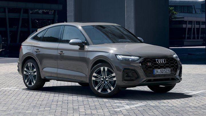 Grey Audi SQ5 Sportback parked in front of a grey building with large window walls