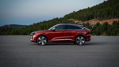 Red Audi SQ5 Sportback zoomed out side profile in mountain road