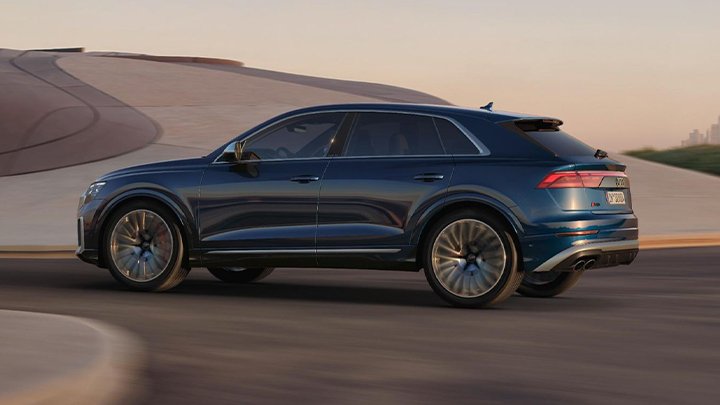 Blue Audi SQ8 is parked sideways in front of a concrete coloured ramp