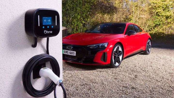 Ohme home wall charger red Audi in background