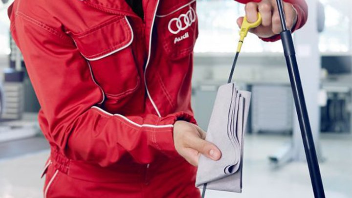 Audi technician checking the oil level on a car