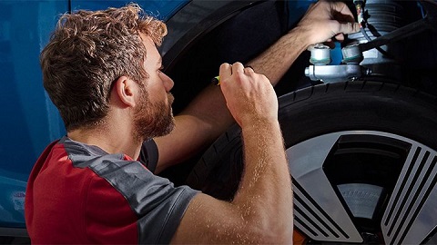 Young technician checking the suspension on an Audi